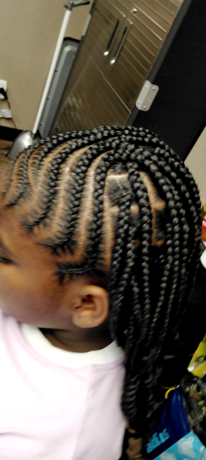 Long kids braids with a creative parting pattern